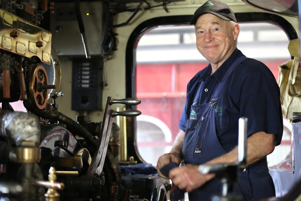 Steam locomotive driver and fireman aboard the footplate of an Abt locomotive on the rack section.